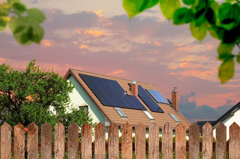 Casa con i pannelli fotovoltaici sul tetto al tramonto