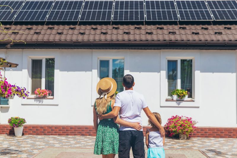 Una famiglia guarda la propria casa con i pannelli fotovoltaici sul tetto