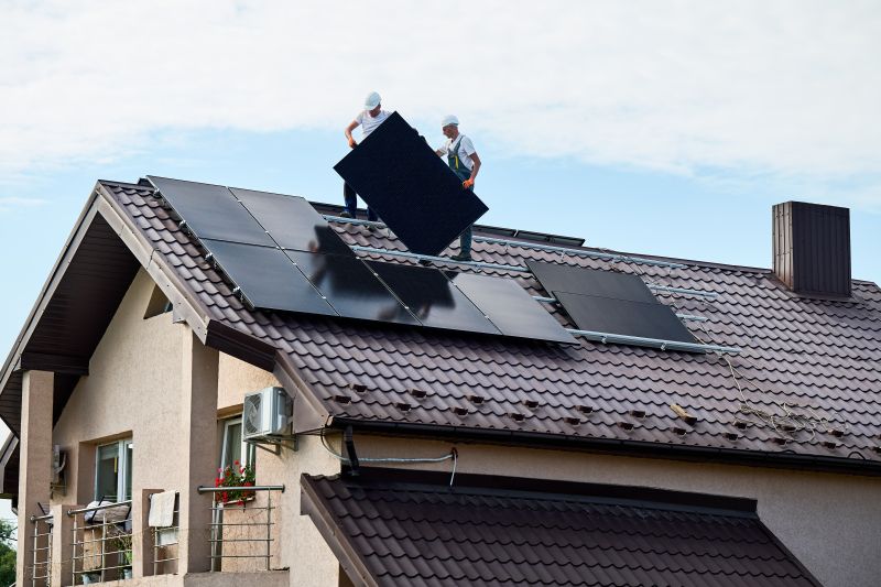 Installatori portano un pannello sul tetto di una casa durante il montaggio